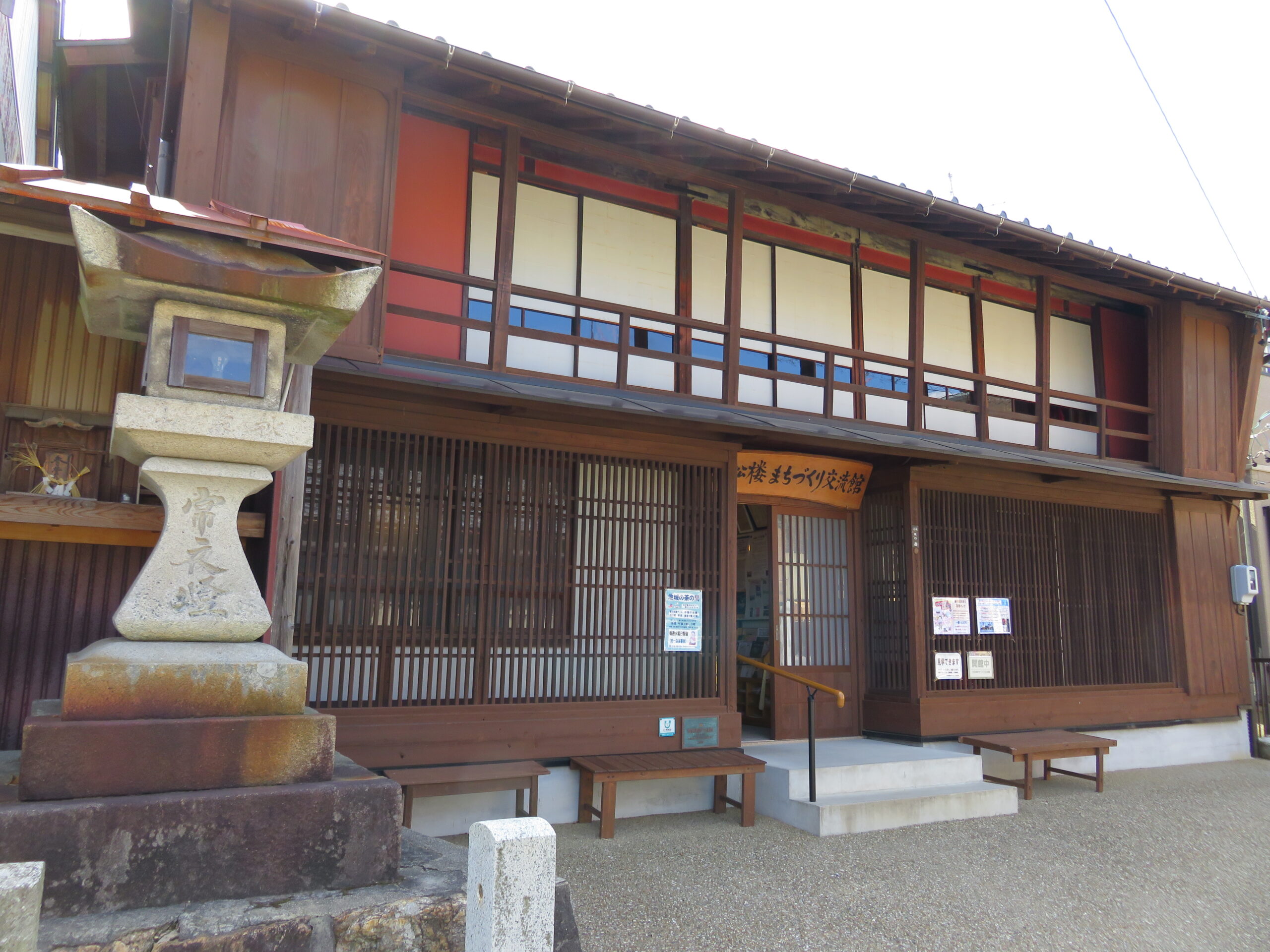 小松楼（こまつろう）まちづくり交流館の外観。木造2階建ての建物で、2階部分の鮮やかなベンガラ色（赤茶色）の壁と格子窓が特徴的。